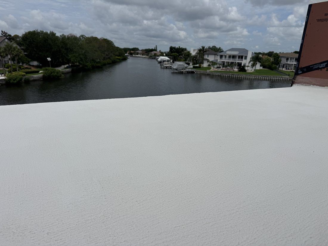 Finished white waterproof deck coating on a canal-front balcony overlooking the water