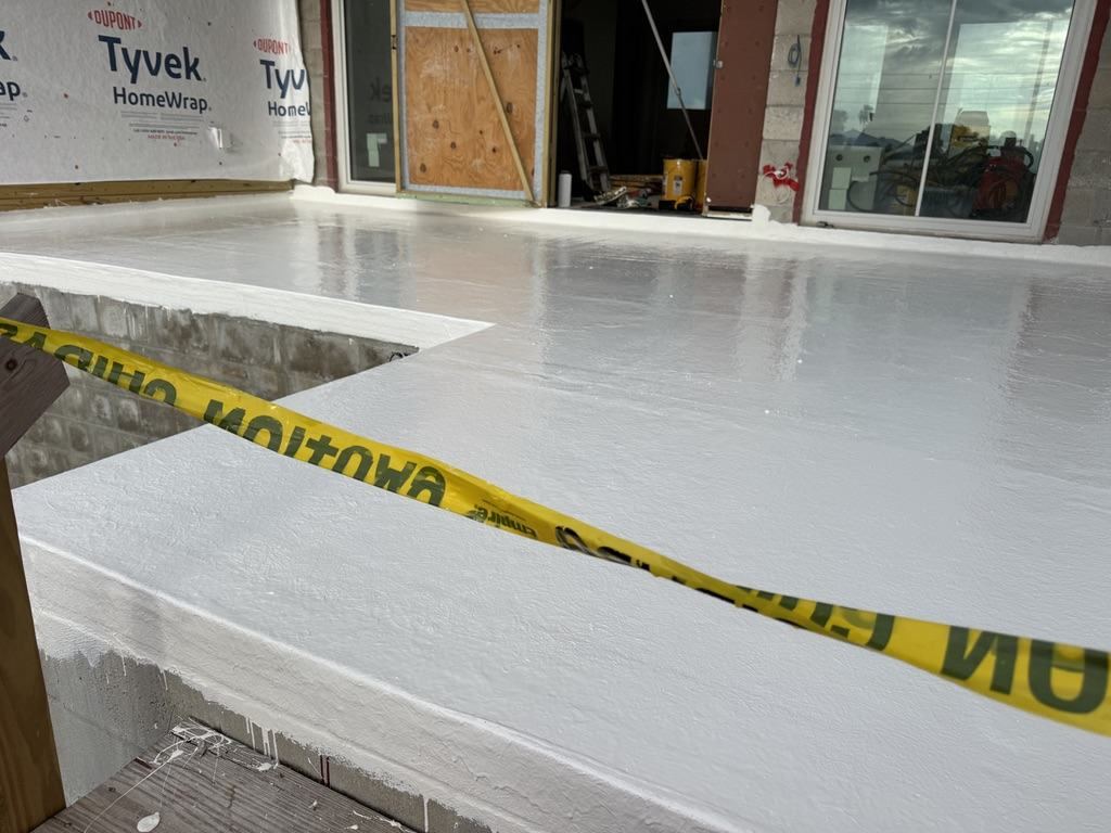 Finished white waterproof coating on a deck and stair landing, carried up over the nosing and riser