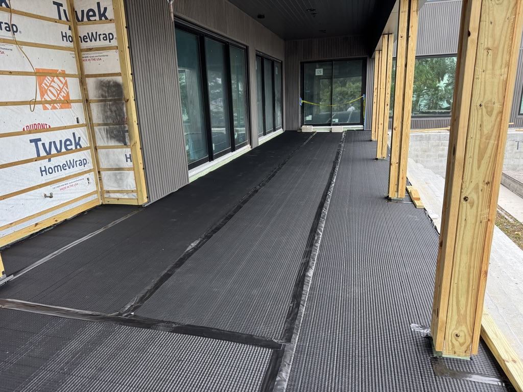 Dimpled drainage and protection mat installed over waterproofed deck substrate, seams taped